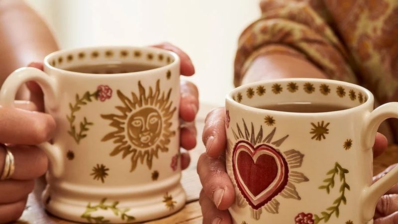 Two Emma Bridgewater mugs held in two hands